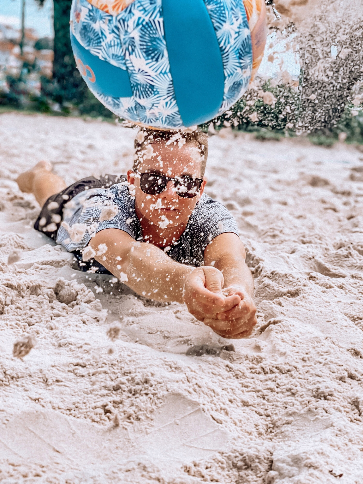 Hráč v pádu na písku při beach volejbalu